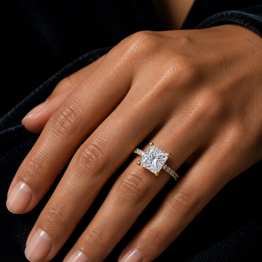 Princess cut solitaire engagement ring with pavé diamond band in yellow gold, featuring a brilliant moissanite or lab-grown diamond center stone, handcrafted by Frigus Jewelry.